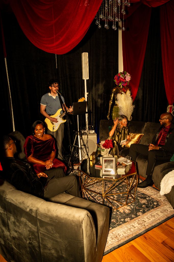 Authentic photograph: a live musician performing for guests in a curated lounge setting at a real Rare Company by RLX gathering