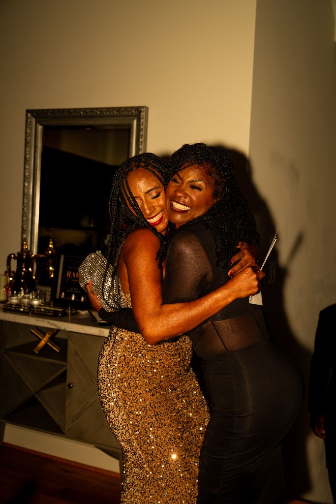 Authentic photograph: two guests sharing a joyful embrace at a real Rare Company by RLX gathering